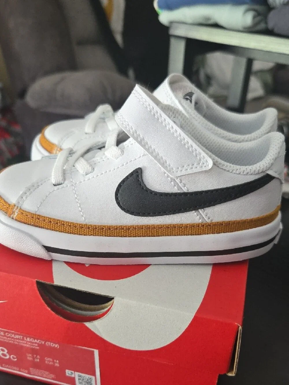Nike Kids White Sneakers with Black Swoosh and Gold Accent